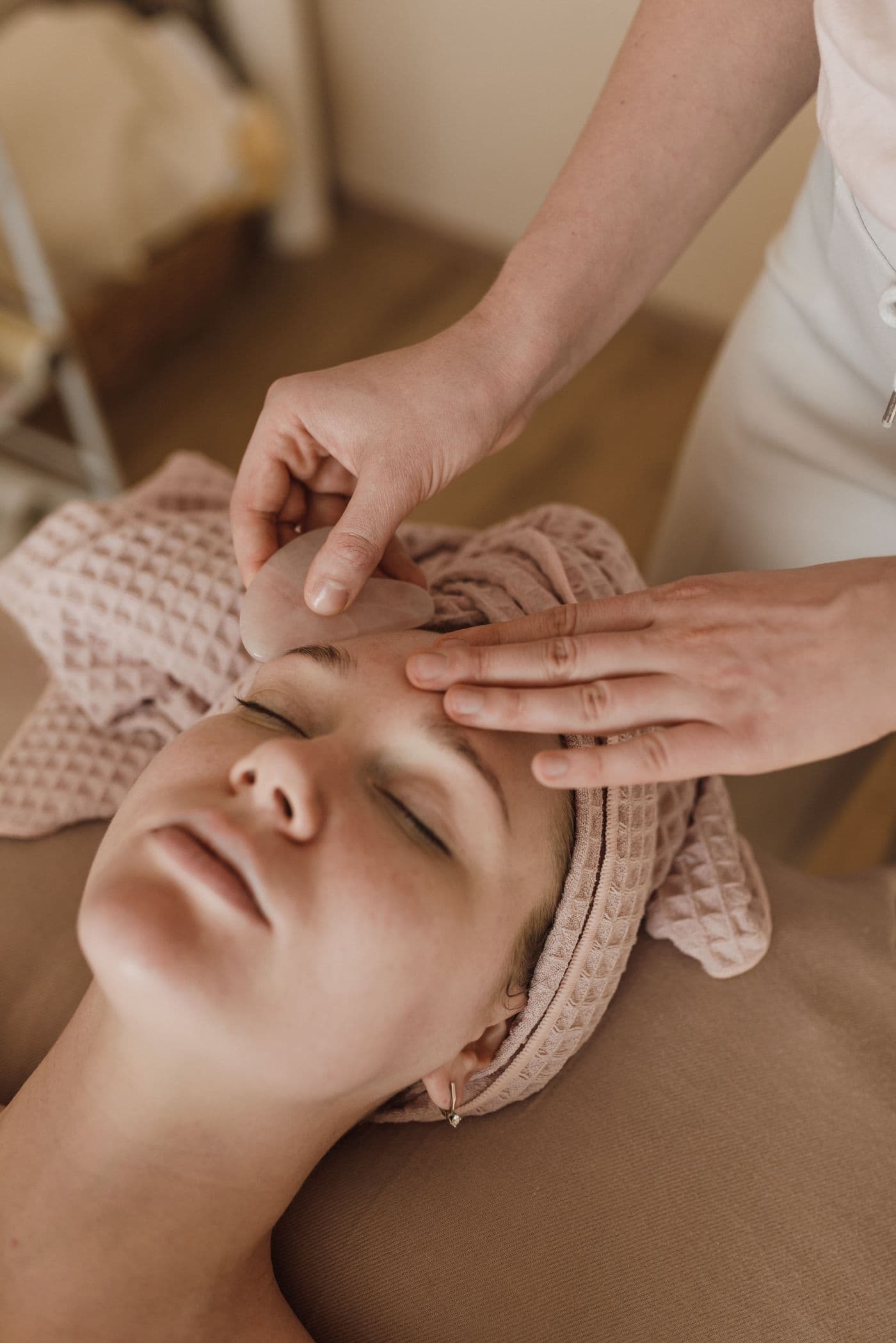 A calm gua sha facial with a stone tool along the brow